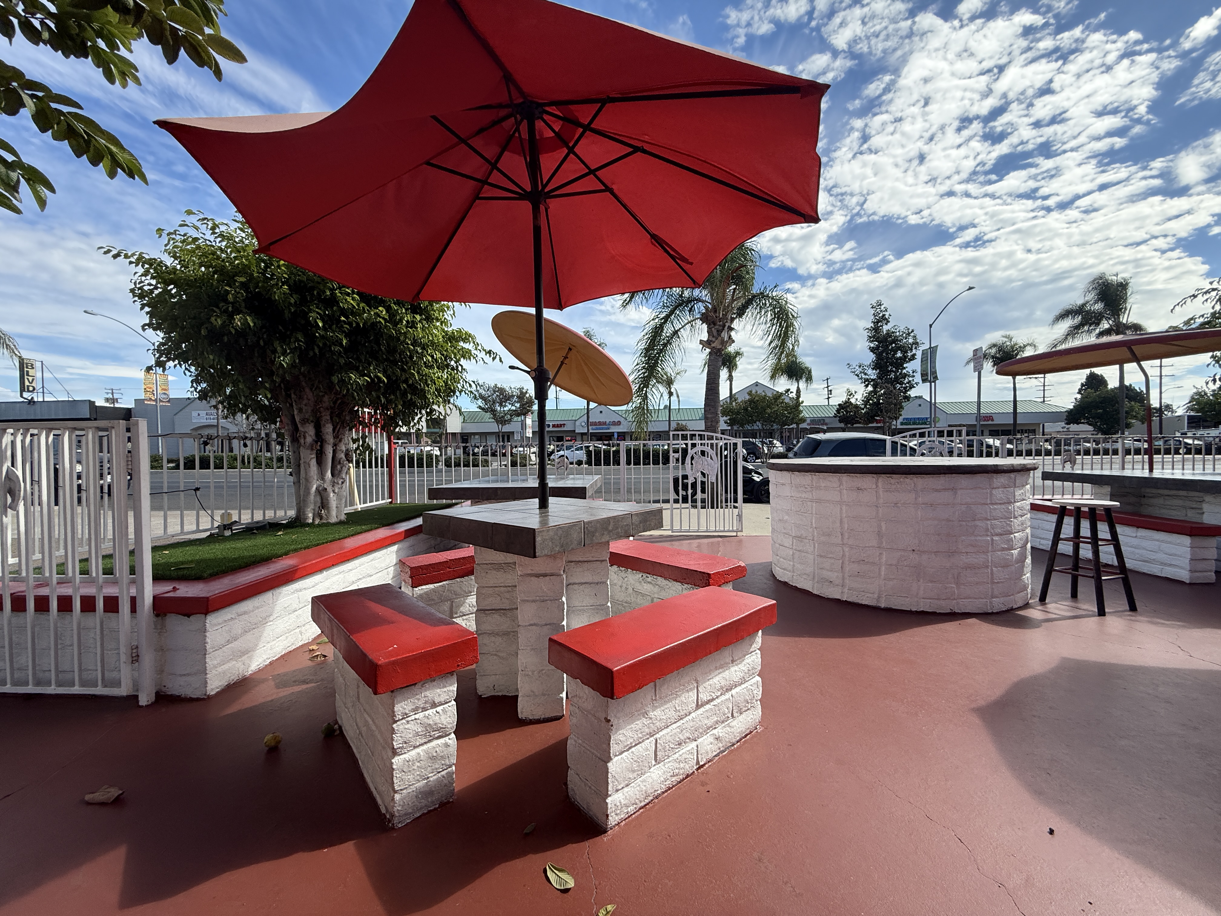 El Rodeo outdoor tables with red umbrellas and benches